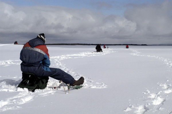 Pêcheur sur lac gelé en Laponie